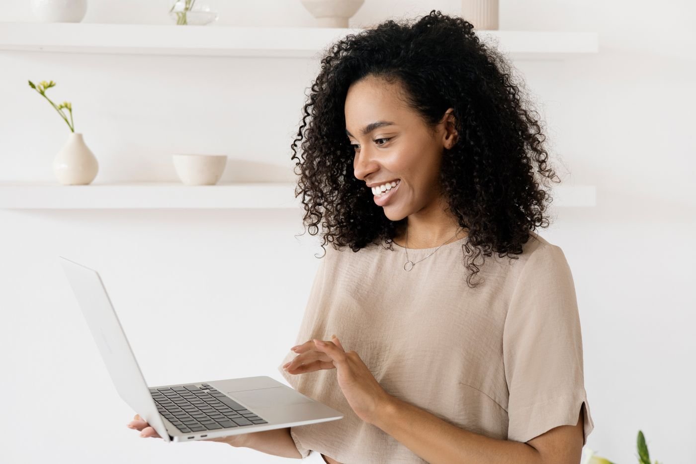 A smiling business owner reviewing her finances on a laptop