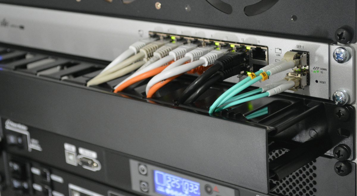 Fiber and network cables connected to a switch in a server rack