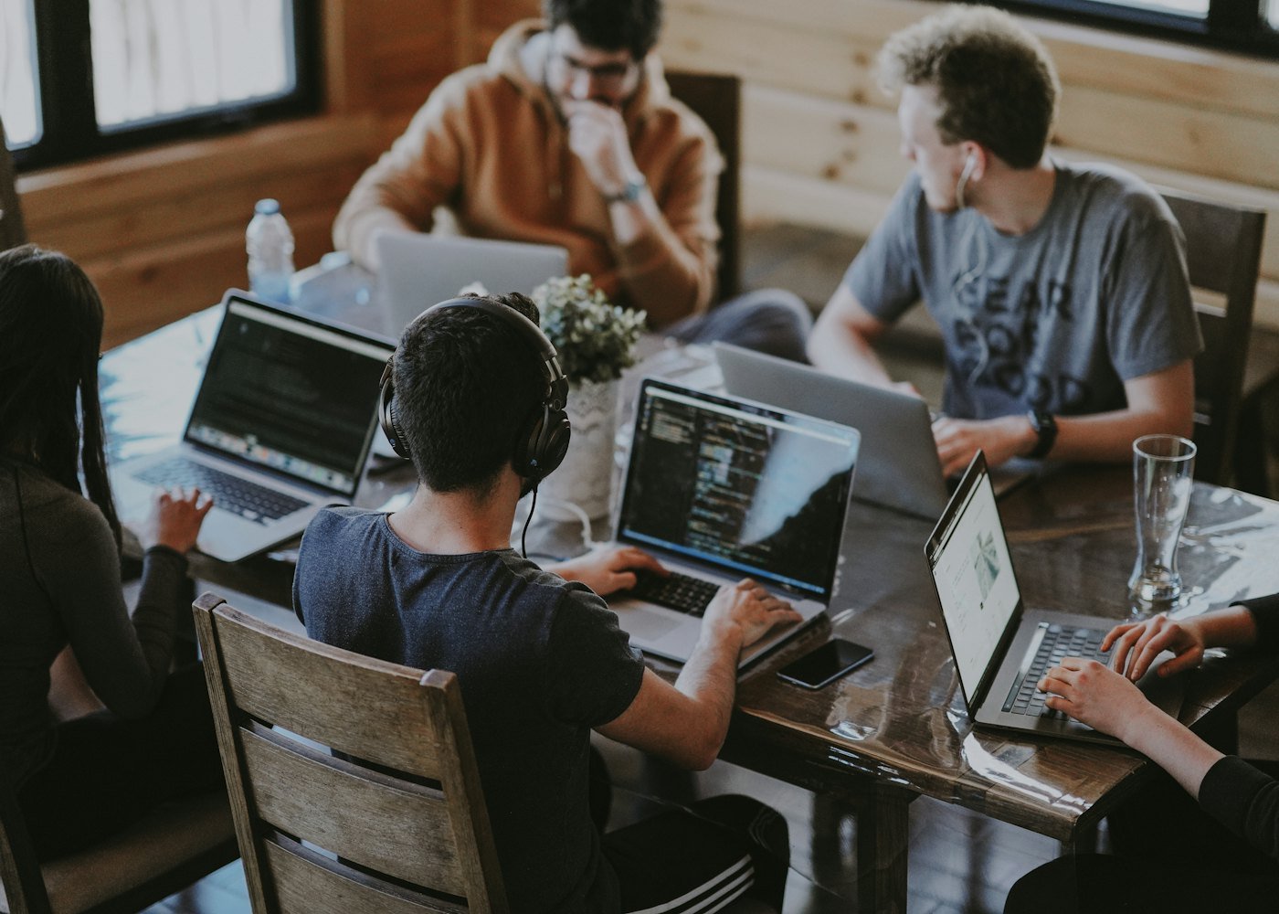 A small team working together on laptops around a shared table