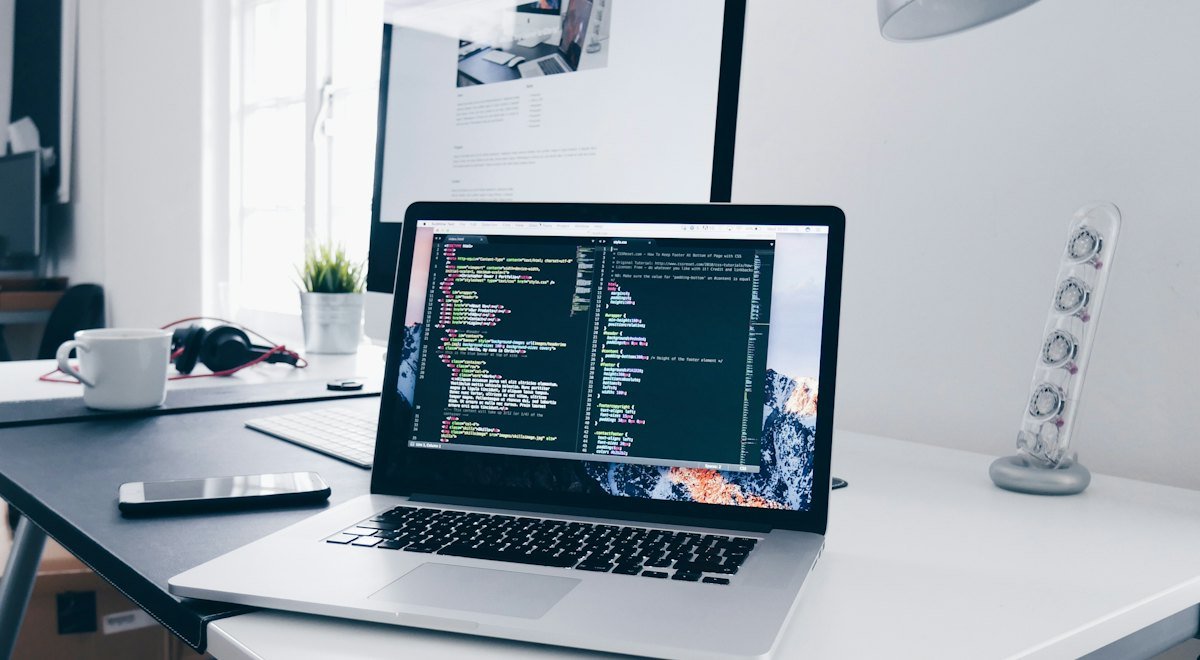 Laptop on a desk showing code in an editor
